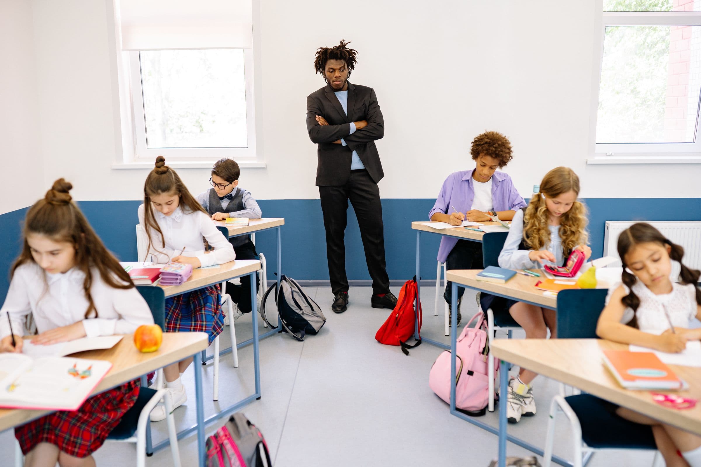 A professional educator standing in a classroom of focused students