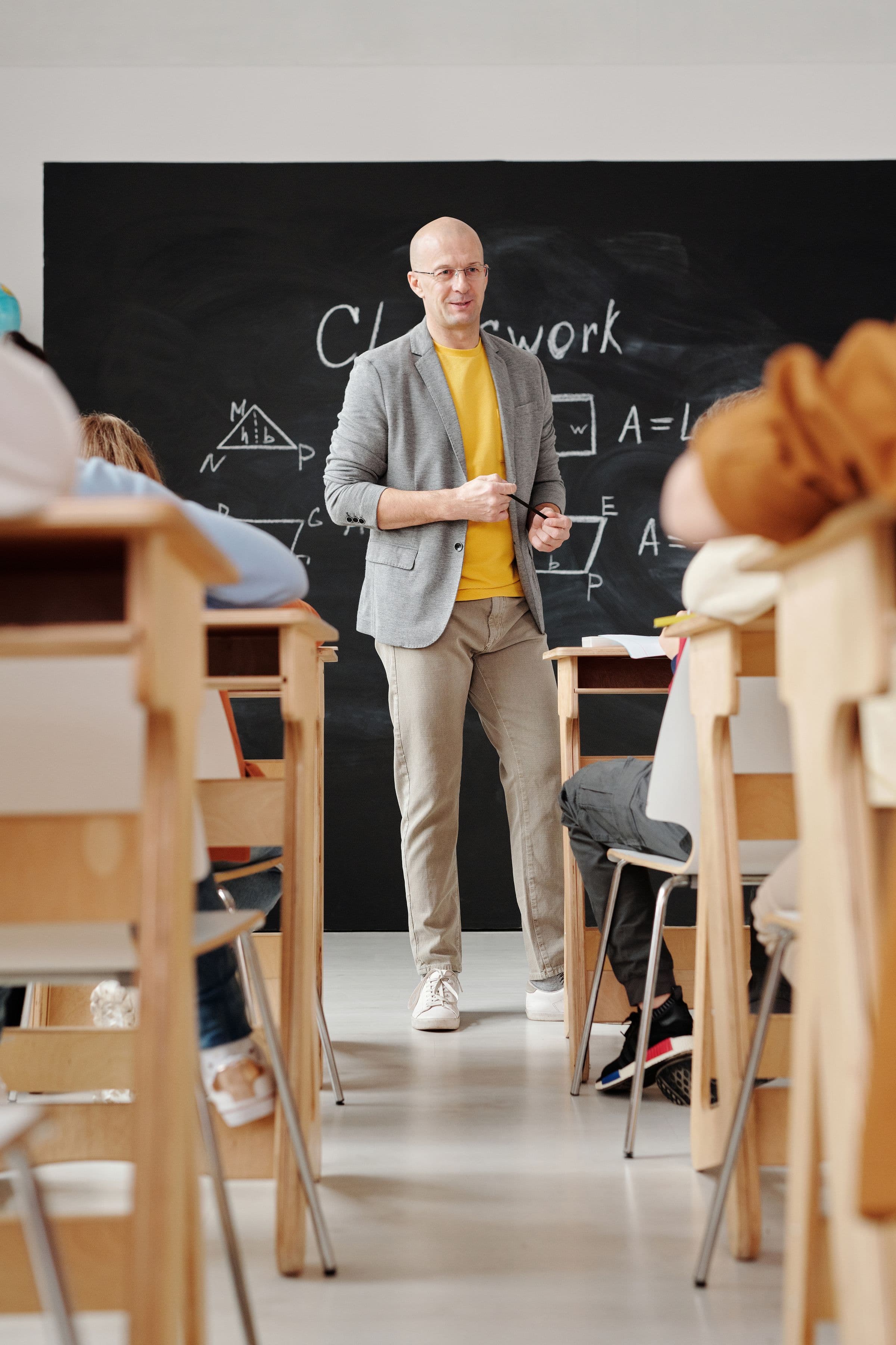 A teacher leading a lesson at the board in a bright classroom